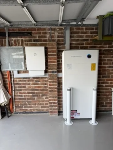 Battery and inverter installed on a brick wall