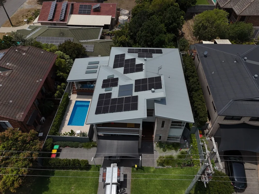 Aerial view of rooftop solar beside a residential swimming pool