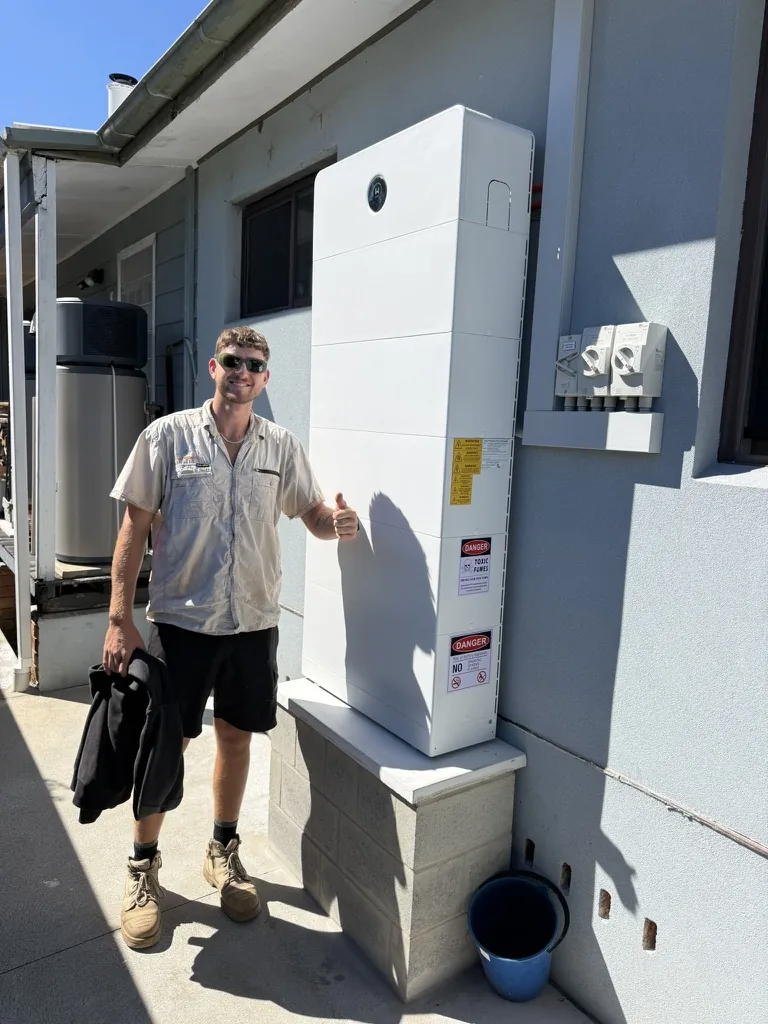 Elite Energy Co. team member beside a completed battery installation