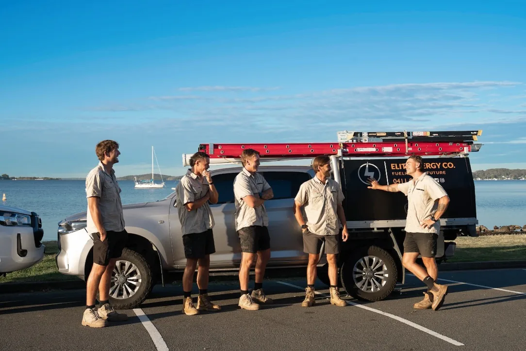 Elite Energy Co. team together beside branded vehicles